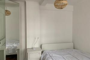 - une chambre blanche avec un lit et un miroir dans l'établissement Contemporary 2 Bedroom Flat in Bayswater, à Londres