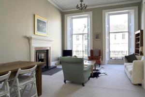 a living room with a fireplace and a table and chairs at Grand New Town 2 Bedroom in Central Edinburgh in Edinburgh
