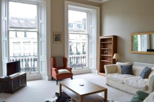 a living room with a couch and chairs and windows at Grand New Town 2 Bedroom in Central Edinburgh in Edinburgh