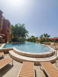 una piscina con bancos en un complejo en The Village at Palmas del Mar en Humacao