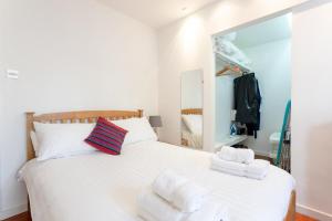 ロンドンにあるFantastic and Bright 1 Bedroom Garden Flatのベッドルーム1室(大きな白いベッド1台、タオル付)