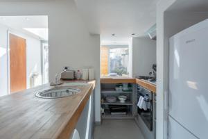 ロンドンにあるFantastic and Bright 1 Bedroom Garden Flatのキッチン(木製カウンター、シンク付)