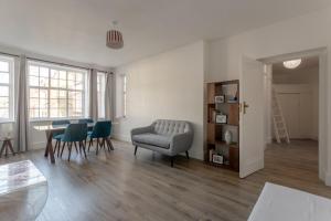 a living room with a table and green chairs at Bright and Lovely 1 Bedroom Flat Belsize in London