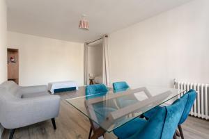 a dining room with a glass table and blue chairs at Bright and Lovely 1 Bedroom Flat Belsize in London