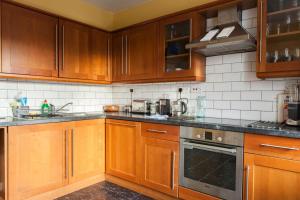 una cucina con armadietti in legno ed elettrodomestici in acciaio inossidabile di Sophisticated Edinburgh Apartment in City Centre a Edimburgo