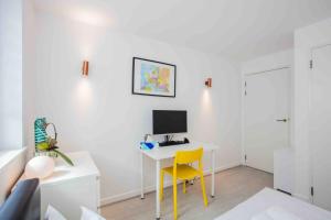 a room with a desk with a computer and a yellow chair at Cosy & Comfortable 2 Bedroom in HackneyShoreditch in London