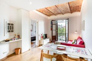 a living room with a red couch and a table at Design 1 Bedroom Apartment near Plaza España in Barcelona