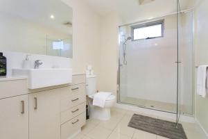a white bathroom with a shower and a toilet at Stunning Two-Storey Apartment in Perth's CBD in Perth