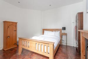 a bedroom with a wooden bed and a wooden dresser at Modern 2 Bedroom flat in Central London in London