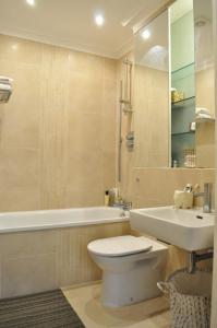 a bathroom with a toilet and a sink and a tub at Bright and Modern 1 Bed Flat in Highbury in London