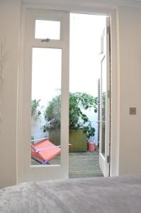 a door leading to a patio with a hammock outside at Bright and Modern 1 Bed Flat in Highbury in London