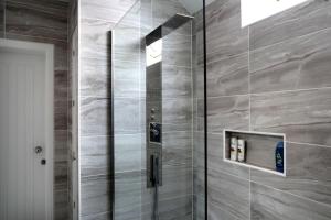 a shower with a glass door in a bathroom at Quiet Ground Floor Mews Flat and parking in Edinburgh