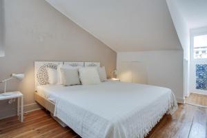 リスボンにあるBright 1 Bedroom top floor apartment with terrace & river viewの白いベッドルーム(白い枕の大きな白いベッド付)