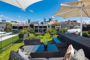 a patio with a table and chairs and an umbrella at Bohemian 1 Bedroom Apartment with Rooftop Terrace in Perth
