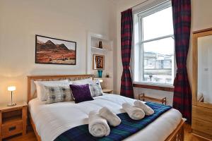 a bedroom with a bed with pillows and a window at Cozy 2 Bedroom Apartment at Heart of the Edinburgh in Edinburgh