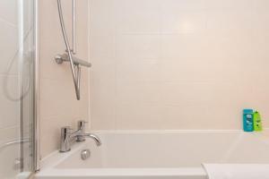 y baño con bañera y lavamanos. en Professionally Cleaned 1 Bed flat in South Kensington, en Londres