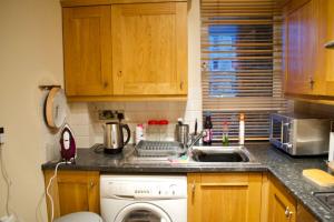 a kitchen with a washing machine and a sink at Newly Refurbed Home with Free Parking in Edinburgh