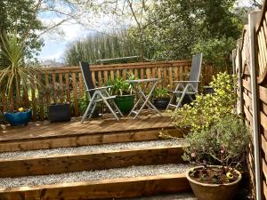 two chairs and a table on a wooden deck at Meander in Penzance