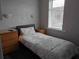 1 dormitorio con 1 cama, vestidor y ventana en Whitehouse Guest House, en Stirling