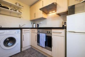 uma cozinha com máquina de lavar e secar roupa em Bright City Centre Flat with Sea 2 Minutes Away em Brighton & Hove