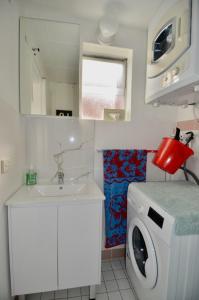 La salle de bains est pourvue d'un lave-linge et d'un lavabo. dans l'établissement Cute Studio Apartment in Maroubra, à Sydney