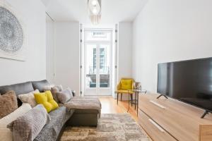a living room with a couch and a large flat screen tv at Spacious 1 Bedroom Apartment near Baixa in Lisbon