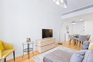 a living room with a couch and a tv and a table at Spacious 1 Bedroom Apartment near Baixa in Lisbon