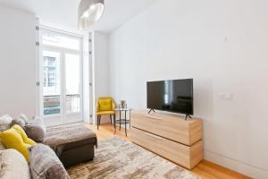 a living room with a couch and a flat screen tv at Spacious 1 Bedroom Apartment near Baixa in Lisbon
