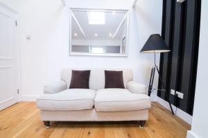 a white couch in a living room with a lamp at Contemporary 1 Bed Flat in Fulham Near The Thames in London