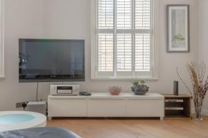 a living room with a flat screen tv on a white cabinet at Fantastic 2 Bedroom Apartment in Central London in London