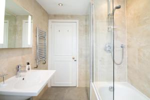 een badkamer met een witte wastafel en een douche bij Contemporary 1 Bed Flat in Fulham Near The Thames in Londen