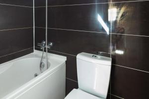 ein Badezimmer mit einem weißen WC und einer Badewanne in der Unterkunft Stunning 2 Bedroom Apartment near Belém in Lissabon