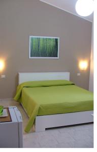 um quarto com uma cama verde e uma janela em B&B Hibiscus em Capoterra