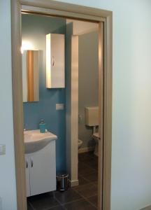 uma casa de banho com um lavatório e um WC em B&B Hibiscus em Capoterra
