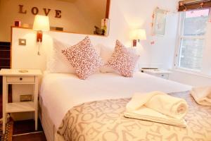 - une chambre avec un grand lit blanc et des oreillers dans l'établissement Cosy Studio Apartment in Edinburgh, à Édimbourg