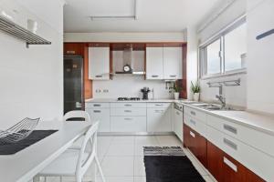 eine weiße Küche mit weißen Schränken und einem Waschbecken in der Unterkunft Spacious 3 Bedroom Apartment in Lisbon in Lissabon