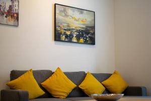 エディンバラにあるBeautifully Renovated Apartment -Central Edinburghのリビングルーム(カウチ、黄色い枕付)