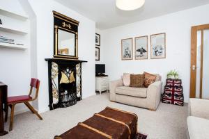 a living room with a fireplace and a chair at Stylish 1 Bedroom Flat in Vauxhall in London