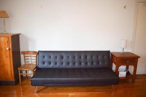 a black couch in a room with a chair and a table at 1 Bedroom Apartment With Incredible Location in Sydney