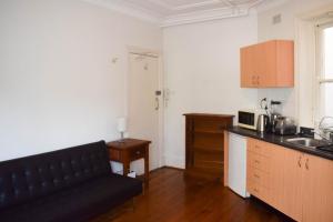 ein Wohnzimmer mit einem Sofa und einer Küche in der Unterkunft 1 Bedroom Apartment With Incredible Location in Sydney