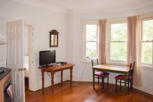 ein Esszimmer mit einem Tisch und einem TV in der Unterkunft 1 Bedroom Apartment With Incredible Location in Sydney