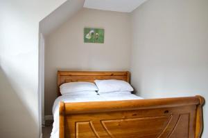a bedroom with a wooden bed with two white pillows at Modern and Charming 2 Bedroom Old Town Apartment in Edinburgh