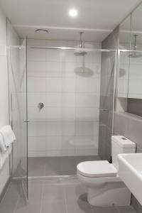 La salle de bains est pourvue d'une douche, de toilettes et d'un lavabo. dans l'établissement Modern Light-Filled Luxury 1Bedroom Apartment in South Melbourne, à Melbourne