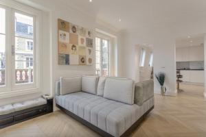 un divano bianco in un soggiorno con finestre di Elegant 1 Bedroom Apartment in South Kensington a Londra