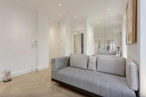 a living room with a couch and a large mirror at Elegant 1 Bedroom Apartment in South Kensington in London