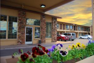 a view of a building with flowers in front of it at Cimarron Inn Klamath Falls in Klamath Falls