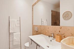 a bathroom with a sink and a toilet and a mirror at Modern Portuguese 1 Bedroom Apartment in Belém in Lisbon