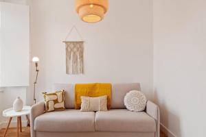 a living room with a couch with pillows on it at Modern Portuguese 1 Bedroom Apartment in Belém in Lisbon