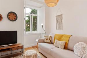 Una sala de estar con un sofá y un televisor. en Modern Portuguese 1 Bedroom Apartment in Belém, en Lisboa 16 fotos más