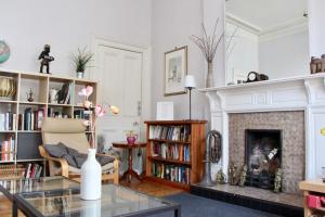 a living room with a fireplace and a fire place at Classic Edinburgh Flat in the heart of Morningside in Edinburgh